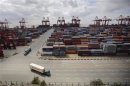 Container trucks drive past the container area at the Yangshan Deep Water Port, part of the newly announced Shanghai Free Trade Zone, south of Shanghai