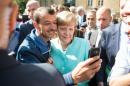 Angela Merkel wins a hero's welcome as she visits a Berlin migrant centre, with Syrians cheering and taking selfies