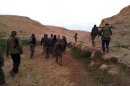 Members of the Free Syrian Army walk with their weapons in Deir el-Zor