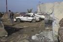 Iraqi security forces inspect the site of bomb attacks at a police station in Ramadi