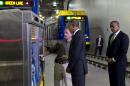 President Barack Obama and Transportation Secretary Anthony Foxx, right, listen as Mark Fuhrmann, New Start Program Director of Metro Transit, left, shows them a ticket vending machine during a tour of the Metro Transit Light Rail Operations and Maintenance Facility, Wednesday, Feb. 26, 2014, in St. Paul, Minn. In Minnesota Obama is expected to speak at Union Depot rail and bus station with a proposal asking Congress for $300 billion to update the nation's roads and railways, and about a competition to encourage investments to create jobs and restore infrastructure as part of the President's Year of Action. (AP Photo/Jacquelyn Martin)