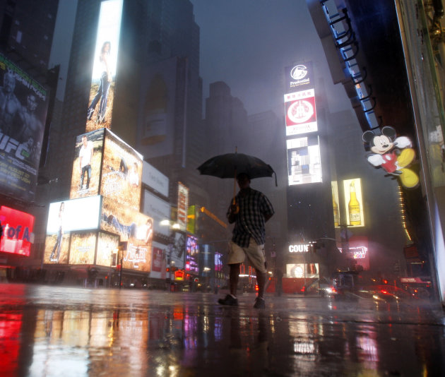 A man walks in Times Square as  Hurricane Irene arrives in New York, on Sunday, Aug. 28, 2011. (AP Photo/Mike Groll)