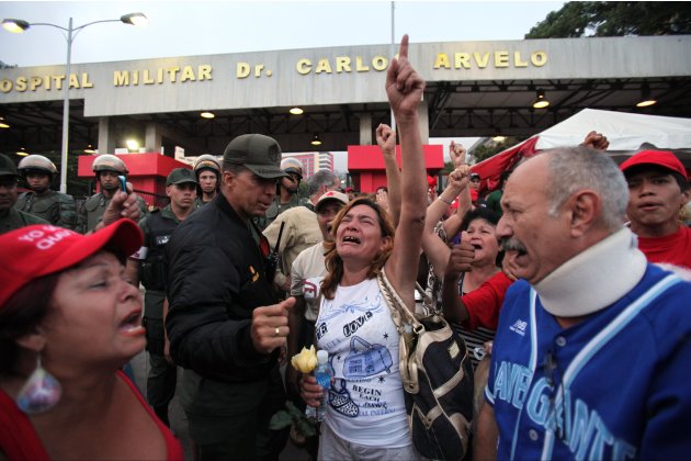 Supporters of Venezuela's President Hugo Chavez react to the news that that Chavez has died, as they gather outside the military hospital where Chavez was being treated in Caracas, Venezuela, Tuesday,