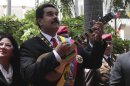 Venezuela's President Nicolas Maduro plays a Venezuelan cuatro as he arrives for a national assembly in Caracas