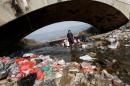 Villagers wash clothes in the garbage-filled Shenling River, in Yuexi county, Anhui province
