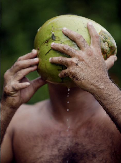 In this photo taken Wednesday Aug. 24, 2011, Yoandri Hernandez Garrido, 37, known as "Twenty-Four," drinks juice from a coconut in Baracoa, Guantanamo province, Cuba.  Hernandez is proud of his extra 