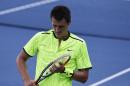 Bernard Tomic, of Australia, adjusts the strings on his racket between serves from Damir Dzumhur, of Bosnia and Herzegovina, during the first round of the U.S. Open tennis tournament, Tuesday, Aug. 30, 2016, in New York. (AP Photo/Alex Brandon)