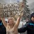 A topless Ukrainian protester is arrested by Swiss police after climbing up a fence at the entrance to the congress center where the World Economic Forum takes place in  Davos, Switzerland Saturday, Jan. 28, 2012. The activists are from the group Femen, which has have become popular in Ukraine for staging small, half-naked protests against a range of issues including oppression of political opposition. (AP Photo/Anja Niedringhaus)
