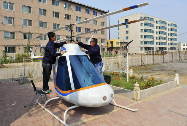 Tian Shengying, a 55-year-old blacksmith adjusts the airscrew of a helicopter he made single-handedly, in Shenyang