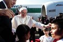Mexico's President Felipe Calderon, left, looks on as Pope Benedict XVI is greeted by children at the airport in Silao, Mexico, Friday March 23, 2012. Benedict's weeklong trip to Mexico and Cuba is his first to both countries. (AP Photo/Gregorio Borgia)