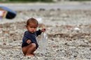 A Roma child, a refugee from Kosovo, plays with a plastic bottle at the camp Vrela Ribnicka in Podgorica