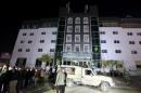 People gather at the Capitol Hotel, the site of a deadly fire, in Erbil