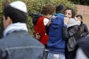 Students comfort each other at the Ozar Hatorah Jewish school where a gunman opened fire killing four people in Toulouse, southwestern France, Monday, March 19, 2012. A father and his two sons were among four people who died Monday when a gunman opened fire in front of a Jewish school in a city in southwest France, the Toulouse prosecutor said Monday. (AP Photo/Remy de la Mauviniere)