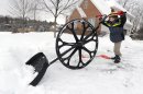 Nathan Lee, 5, uses a "wovel" to remove snow from his driveway along Megan Drive, in State College, Pa. A major winter storm hit Centre County Wednesday and the clean up continues Thursday, Dec. 27, 2012. (AP Photo/Centre Daily Times, Nabil K. Mark)