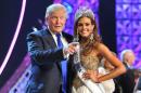 FILE - In this June 16, 2013 file photo, Donald Trump, left, and Miss Connecticut USA Erin Brady pose onstage after Brady won the 2013 Miss USA pageant in Las Vegas, Nev. Univision says it is dropping the Miss USA Pageant and says it will cut all business ties with Donald Trump over comments he made about Mexican immigrants. The network said Thursday, June 25, 2015, it will not air the pageant on July 12, as previously scheduled, and has ended its business relationship with the Miss Universe Organization due to what it called "insulting remarks about Mexican immigrants" by Trump, a part owner. (AP Photo/Jeff Bottari, File)