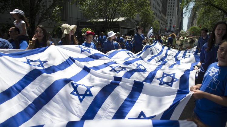 FILE - In this Sunday, June 1, 2014 file photo, revelers carry a banner made of Israeli flags as they march up Fifth Avenue during the Celebrate Israel Parade. Once a unifying cause for generations of American Jews, Israel is now bitterly dividing Jewish communities. (AP Photo/John Minchillo)