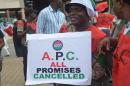 A worker carries a placard changing the ruling "All Progressives Congress (APC)" to "All Promises Cancelled" as he marches during a protest demanding that the government reinstate prices of fuel at 86.50 naira ($0.43, 0.38 euros) per litre in Lagos