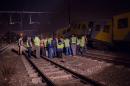 Railway inspectors and emergency personnel stand near the site of a train crash in Johannesburg on July 17, 2015