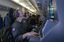 In this photo provided by the U.S. Navy, crew members on board an aircraft P-8A Poseidon assist in search and rescue operations for Malaysia Airlines flight MH370 in the Indian Ocean on Sunday, March 16, 2014. Malaysian authorities on Sunday examined a flight simulator that was confiscated from the home of one of the missing jetliner's pilots. The Boeing 777 went missing less than an hour into a March 8, flight from Kuala Lumpur to Beijing as it entered Vietnamese airspace. (AP Photo/U.S. Navy, Eric A. Pastor)