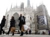 People walk past the Duomo cathedral in downtown Milan