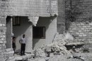 Residents inspect damage and rubble from outside their home, in Aleppo
