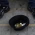 A hat with money belonging to a musician, is seen on the ground as he plays music at the main shopping street in central capital Nicosia, Cyprus, on Saturday, March 30, 2013. Big depositors at Cyprus' largest bank may be forced to accept losses of up to 60 percent, far more than initially estimated under the European rescue package to save the country from bankruptcy, officials said Saturday. (AP Photo/Petros Karadjias)
