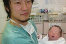 In this Dec. 28, 2012 photo provided by Dr. Kazuhiro Kawamura of the St. Marianna University School of Medicine in Kawasaki, Japan, Kawamura holds a newborn baby whose 30-year-old mother was treated for primary ovarian insufficiency, sometimes called premature menopause, in Tokyo. The mother was one of the five women out of 27 treated who were able to produce usable eggs for in vitro fertilization, Kawamura said. The new technique, described in a report published Monday, Sept. 30, 2013 by the Proceedings of the National Academy of Sciences, raises the promise of a woman with the condition having a baby with her own eggs. (AP Photo/Kazuhiro Kawamura)