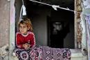 A Syrian girl leans out of a window in a disused house on June 28, 2014 in the Fikirtepe area of Istanbul
