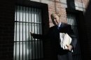 In this April 5, 2012 photo, birth control pioneer Bill Baird, 79, poses by the bars of an old Charles Street Jail cell, currently in the lobby of the Liberty Hotel, in Boston. Forty-five years ago, Baird's arrest for giving spermicidal foam to an unmarried 19-year-old coed set up a constitutional challenge that sent his case to the U.S. Supreme Court. (AP Photo/Elise Amendola)