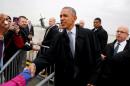 U.S. President Barack Obama greets people as he arrives at O'Hare International Airport in Chicago