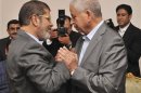 Muslim Brotherhood's President-elect Mohamed Mursi shakes hand with Egyptian political Dr.Abdel Gelil Mostafa at the presidential palace in Cairo