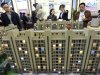 In this April 21, 2012 photo, people check a scale model of a housing project at a real estate fair in Nanjing, in eastern China's Jiangsu province. State media reported Sunday, July 8, 2012, that China's top economic official has ordered local officials to enforce rules aimed at cooling a surge in housing prices. (AP Photo)  CHINA OUT