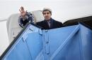U.S. Secretary of State Kerry waves while boarding his plane at Franz-Josef-Strauss Airport in Munich