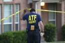 An ATF agent lifts crime scene tape outside the scene of two murders Thursday morning, Aug. 8, 2013, in DeSoto, Texas. Four people were killed at two different locations in South Dallas County and the suspected shooter is in police custody. (AP Photo/LM Otero)
