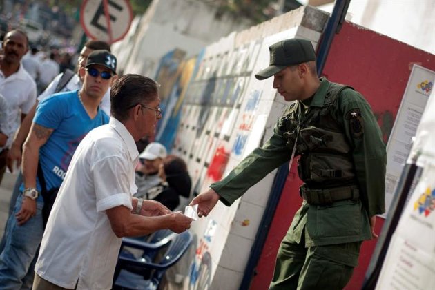 CAR41. CARACAS (VENEZUELA), 07/10/2012.- Un soldado solicita la documentación a un hombre hoy, 07 de octubre de 2012, durante la jornada de elecciones presidenciales que se está celebrando en Venezuela. Alrededor de 19 millones de venezolanos decidirán quién va a ser el gobernante que dirigirá el país durante los próximos seis años. EFE/MIGUEL GUTIÉRREZ