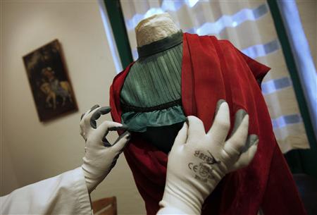 A restoration expert arranges the ruffles on a blouse that belonged to iconic Mexican painter Frida Kahlo at the "Blue House" in the neighborhood of Coyoacan in Mexico City