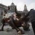 A man touches on a statue of charging bull which is a similar version of his Wall Street Bull, on Tuesday Feb. 7, 2012 in Shanghai, China. Mainland Chinese shares lost ground Tuesday with the benchmark Shanghai Composite Index falling 1.68 percent, or 39.23 points, to 2,291.90 after dipping more than 2 percent earlier in the day. (AP Photo/Eugene Hoshiko)