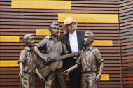 El músico australiano Barry Gibb posa junto a una estatua en honor de Barry, Robin y Maurice Gibbs, componentes del grupo musical Bee Gees, durante la inauguración oficial del Paseo de los Bee Gees en Australia. EFE/Archivo