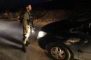 An Israeli soldier stops a car in the village of Beit Anun, West Bank, Thursday, April 2, 2015. An Israeli has gone missing in the West Bank and troops are searching for the man amid fears he could have been abducted. Last year, Palestinians abducted and killed three Israeli teenagers sparking a chain of events that led to a 50 day war in Gaza. (AP Photo/Mahmoud Illean)