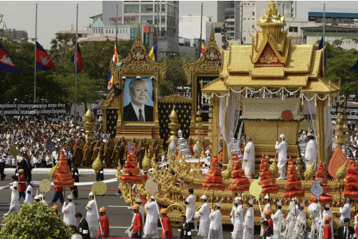 The chariot carrying the casket of Cambodia's late former King Norodom Sihanouk leads the funeral procession in Phnom Penh, Friday, Feb. 1, 2013. Thousands of mourners accompanied the gilded chariot carrying the body of former King Sihanouk - the dominant figure of modern Cambodia - in the funeral procession Friday to a cremation ground next to the palace where he was crowned more than 70 years ago. Norodom Chakrapong, brother of Cambodian King Norodom Sihamoni, is seen at third right at the chariot.(AP Photo/Heng Sinith)
