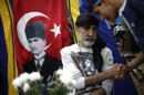 Protesters greet each other near a portrait of Mustafa Kemal Ataturk, founder of modern Turkey, at Gezi Park near Taksim Square in Istanbul