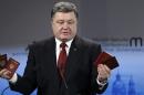 Ukraine's President Petro Poroshenko holds Russian passports claiming they are proof of the presence of Russian troops in Ukraine as he addresses the 51. Security Conference in Munich, Germany, Saturday, Feb. 7, 2015. The conference on security policy takes place from Feb. 6, 2015 until Feb. 8, 2015. (AP Photo/Stringer)