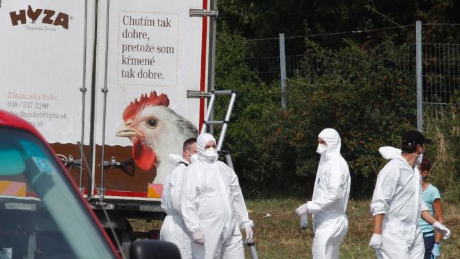 Forensic officers work at a truck found to contain a large number of dead migrants on a motorway near Neusiedl am See, Austria, on August 27, 2015