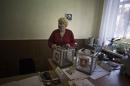 A Ukrainian woman, who is a member of the district electoral committee, holds a ballot box during preparations for Sunday's referendum at a polling station in Simferopol, Ukraine, Saturday, March 15, 2014. Tensions are high in the Black Sea peninsula of Crimea, where a referendum is to be held Sunday on whether to split off from Ukraine and seek annexation by Russia. (AP Photo/Manu Brabo)