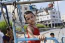 Palestinian May Amin, 2, rides a swing while celebrating on the first day of the Muslim festival of Eid al-Fitr in Gaza City, in the northern Gaza Strip, Monday, July 28, 2014. The Amin family, originally from the Shijaiyah neighborhood of Gaza City, moved in with relatives in another part of town because of heavy Israeli strikes in their area. As Muslims began celebrating the Eid al-Fitr holiday on Monday that marks the end of the fasting month of Ramadan, there was mostly fear and mourning instead of holiday cheer in the Gaza Strip. (AP Photo/Lefteris Pitarakis)