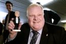 Toronto Mayor Rob Ford shows off his bobblehead doll at City Hall in Toronto