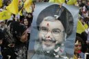 A Hezbollah supporter carries a poster of Hezbollah leader Nasrallah during a rally marking Resistance and Liberation Day in Beirut