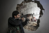 In this Sunday, Dec. 2, 2012 photo, a Free Syrian Army fighter aims his weapon during clashes with government forces in Aleppo, Syria. (AP Photo/Narciso Contreras)
