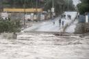 Residents watch the rising flood waters of the Copiapo River, in Copiapo, Chile, Wednesday, March 25, 2015. Unusually heavy thunder storms and torrential rains that began on Tuesday have blocked roads, caused power outages and affected some 600 people on this normally dry region. (AP Photo/Aton Chile)