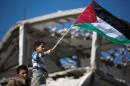 A boy waves a Palestinian flag during a rally in Beit Hanun in the northern Gaza Strip on January 30, 2015